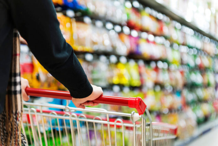 Lady pushing a shopping cart in the supermarket. Fozzy Group improves its work with SAP cloud technologies